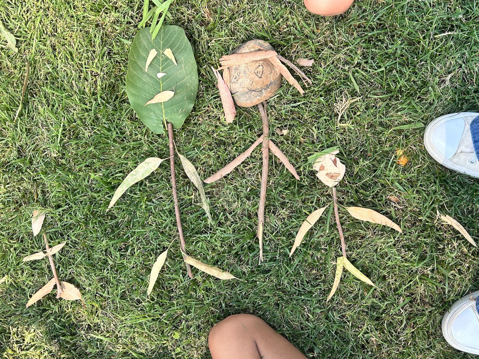Nature art figures built from leaves, sticks, and river rocks by Wild Things students during an outdoor hands-on project