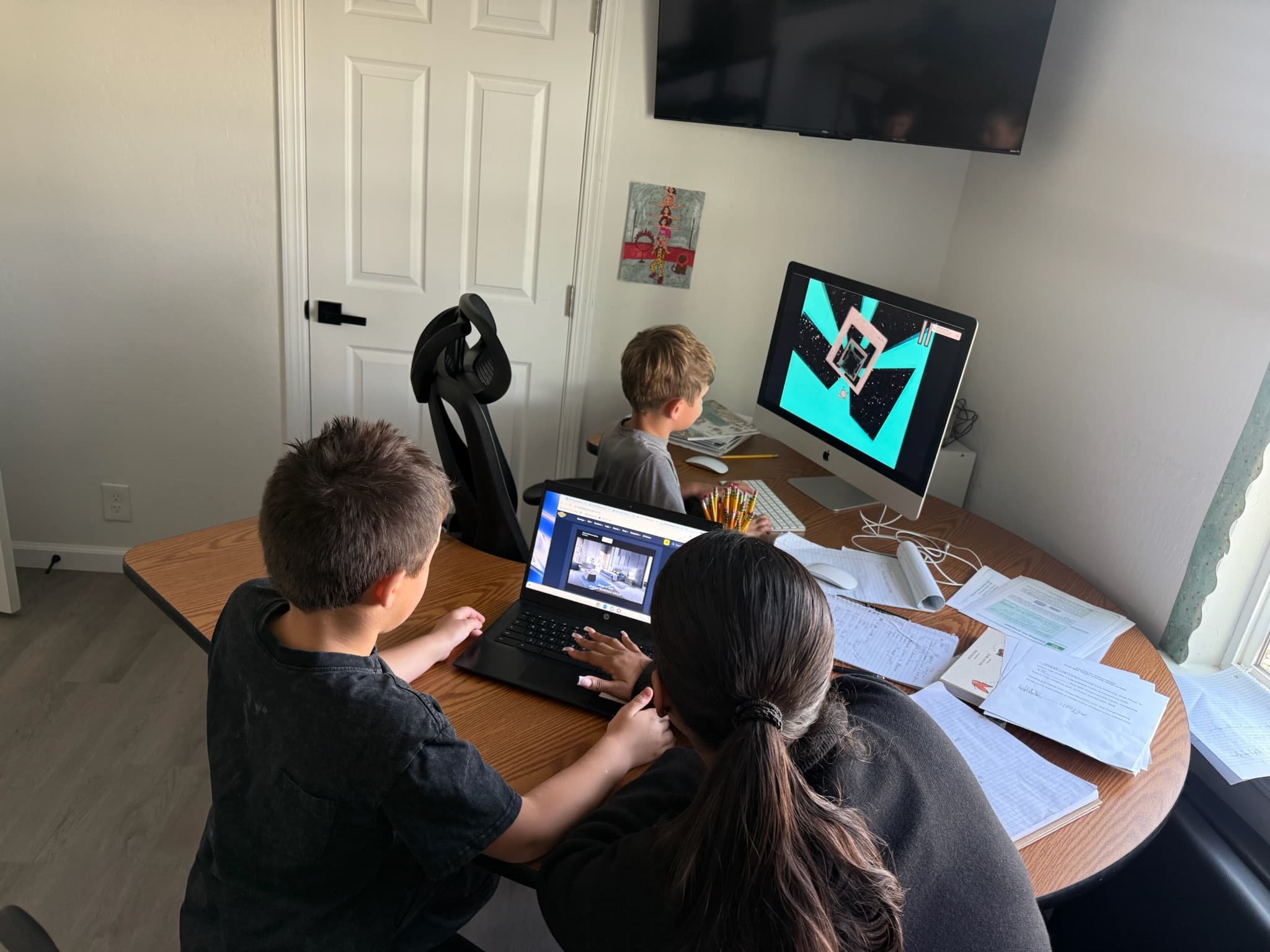 Students working on laptops and a desktop computer during a technology project