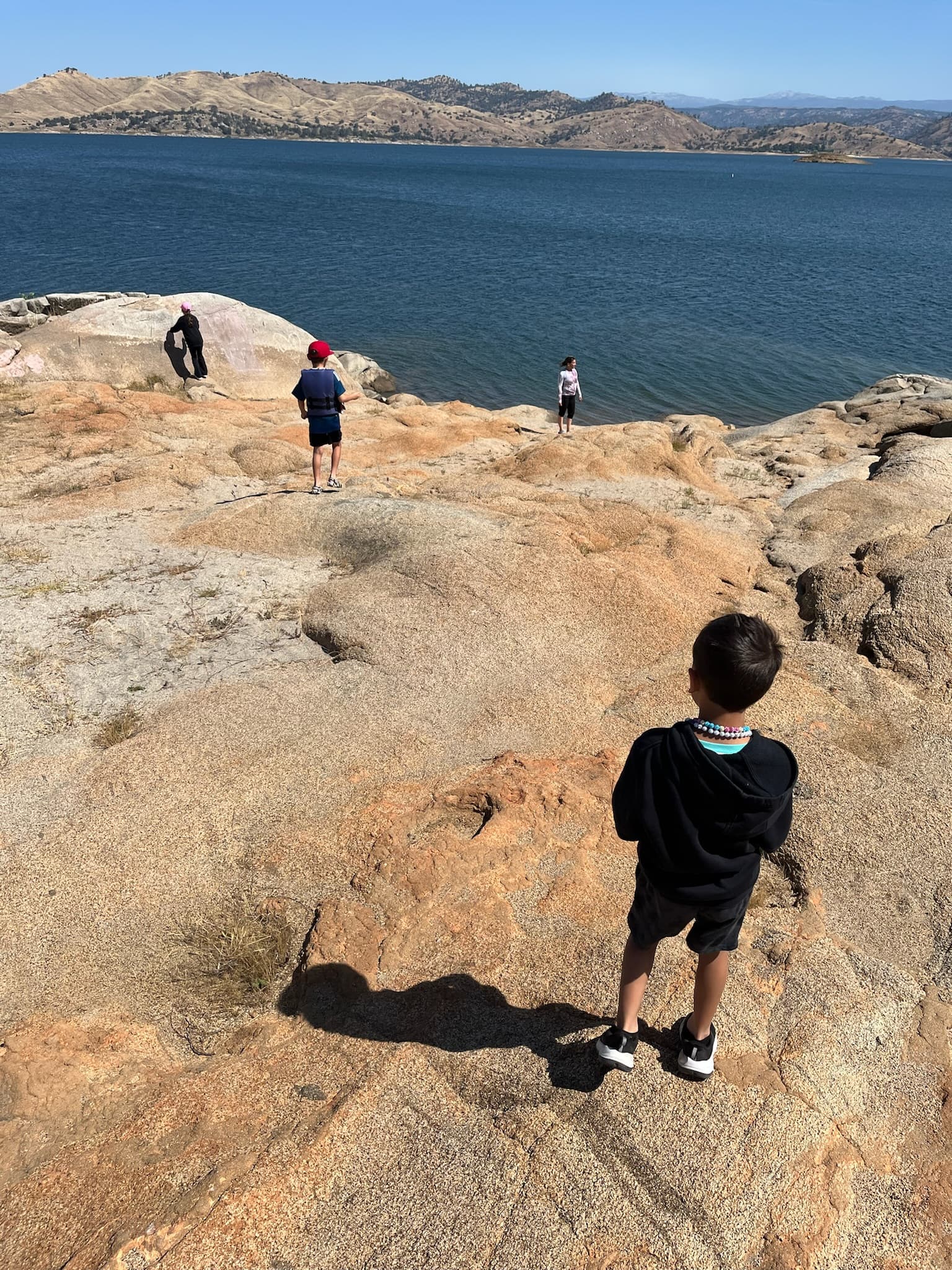 Students exploring granite shoreline at the lake on a field trip